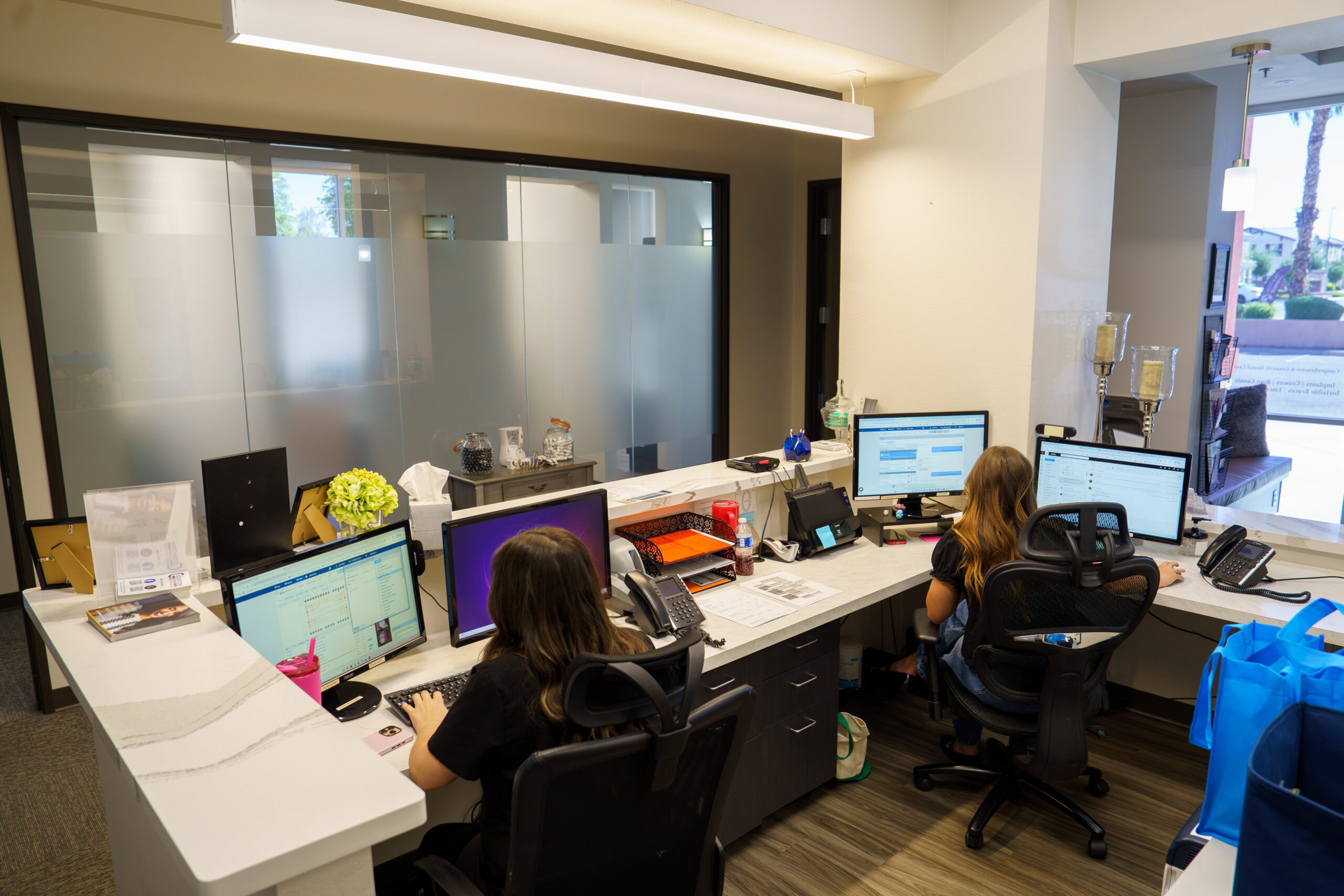 Two dental front desk staff at a receiving area